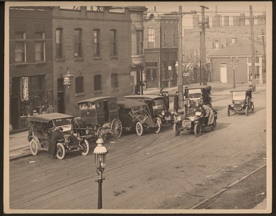 View of Unidentified Street with Several Automobiles and a Horse-Drawn Delivery Wagon from the St. Louis Bakery Company Parked Along the Curb by William G. Swekosky